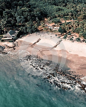 Vertical aerial view of low sea tides washing up on the shore of a tropical island in Thailand