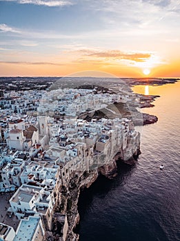 Vertical aerial view of a sunset sky over the skyline of Polignano a Mare, Puglia, Italy photo