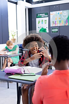 Vertical of african american female school teacher and boy using sign language in class