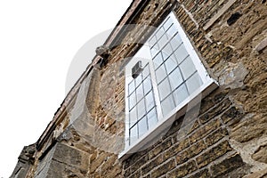 Vertical aspect of a medieval house showing the leaded first floor window.