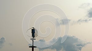 Vertical axis wind turbine utilize renewable wind energy while spinning against blue sky.