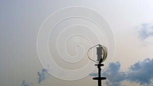 Vertical axis wind turbine utilize renewable wind energy while spinning against blue sky.