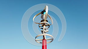 Vertical axis wind turbine utilize renewable wind energy while spinning against blue sky.