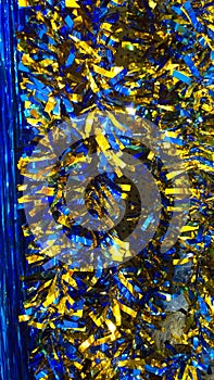 Vertical background of blue and gold shiny Classic Tinsel Garland. Traditional Christmas decoration. Xmas collection magic festive