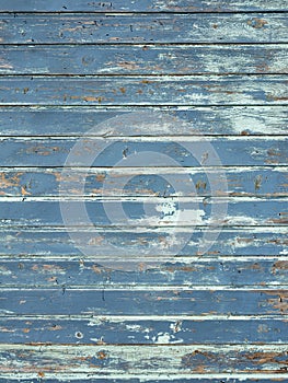 vertical background consisting of wheathered old grungy blue planks with peeling paint