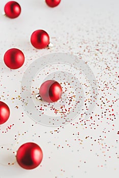 Vertical background with red Christmas balls and colorful star shaped confetti