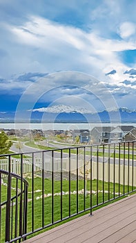 Vertical Balcony with wooden floor and metal railing overlooking lake and mountain