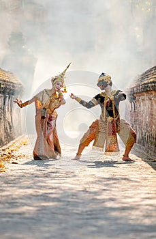 Vertical beautiful Asian woman wear Thai traditional dress action of dancing together with Thai classic masked from the Ramakien