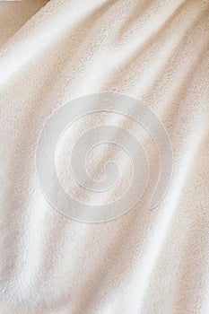 Vertical beautiful cozy plaid made of white fabric with drapery pile lies in diagonal soft folds photo