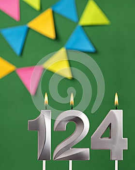 Vertical birthday card with number 124 candle - Green background with pennants