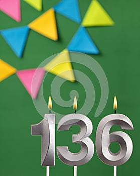 Vertical birthday card with number 136 candle - Green background with pennants