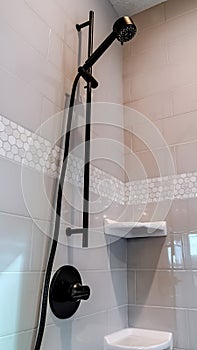 Vertical Black round shower head and handle inside the walk in bathroom shower stall