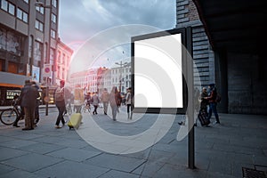 Vertical blank billboard in the city center with Mock up. The layout is located in a crowded street with people.