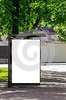 Vertical blank white billboard at bus stop on city street.