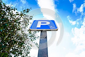 A vertical blue pole sign marking a parking for disabled vehicles