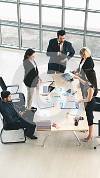 Vertical business background of group of businesspeople around meeting table and having business discussion in office