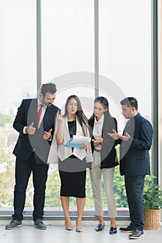 Vertical business background of group of businesspeople standing together and having business discussion