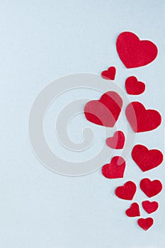 Vertical card Valentine`s Day. Red hearts on a gray-blue background