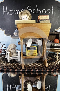 Vertical child doll at desk being home schooled photo