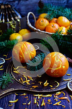 Vertical Christmas composition. Oranges in the shape of Christmas balls and tangerines in a basket on a dark wooden