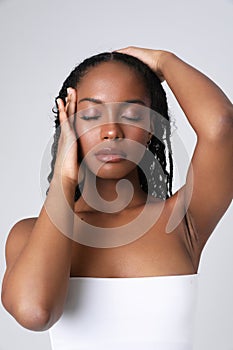 Vertical close-up of African American young woman poses indoor. Isolated.