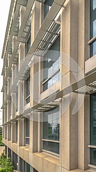 Vertical Close up of the glass windows and concrete exterior wall of a modern building