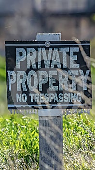 Vertical Close up of a Private Property No Trespassing sign on a sunny day