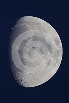 Vertical close-up shot  of Three Quarter moon in a black night sky  background