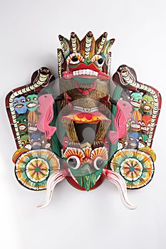 Vertical  close up shot of a traditional Sinhalese Sri Lanka carved wooden Raksha mask of the Maha Kola demon with photo