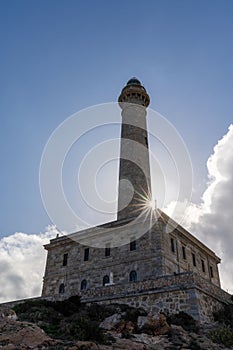 Vertical close up view of the Cape Palos lighthouse in Spain with a sun star photo