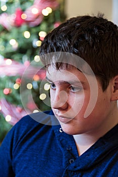Vertical closeup of cute glum round-faced teenager boy photo