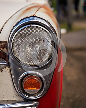 Vertical closeup of headlights on a vintage car