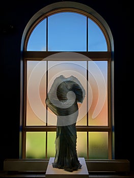 Vertical closeup of Karen LaMonte with colorful, blurred window in the background