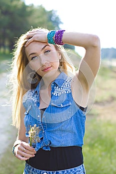 Vertical closeup portrait of a cute blonde on nature background