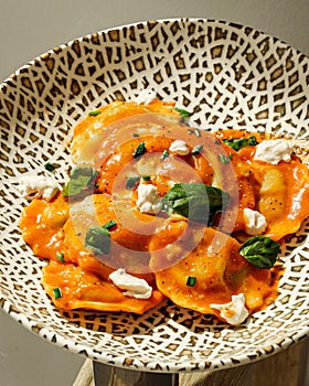 Vertical closeup of ricotta cheese ravioli on a plate with tiger patters