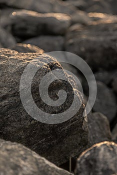 Vertical closeup of rocks under the sunlight with a blurry background
