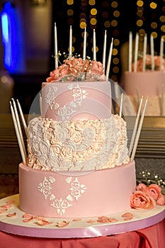 Vertical closeup shot of a beautiful three-layered cake with rose decorations