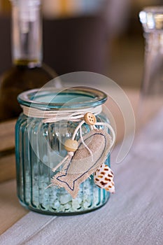 Vertical closeup shot of a blue glass bank with hanging fish decoration