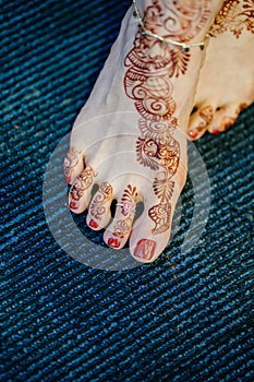 Vertical closeup shot of a bride's feet covered in henna for her wedding