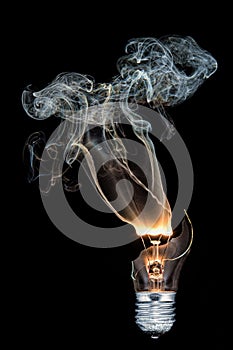 Vertical closeup shot of a burned-out light bulb with smoke coming out