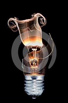 Vertical closeup shot of a burned out light bulb with smoke coming out