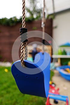 Vertical closeup shot of a children swing in a park with a blurred background