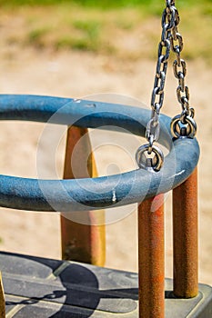 Vertical closeup shot of a children swing on a playground