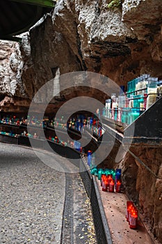Vertical closeup shot of colorful candles in a cave under a cliff