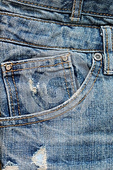 Vertical closeup shot of a front pocket of blue jeans