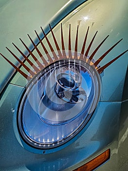 Vertical closeup shot of funny eyelash decorations on a car light