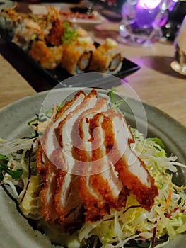 Vertical closeup shot of a gourmet dish of salad with crispy chicken slices