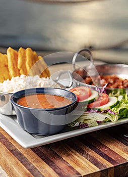 Vertical closeup shot of a gourmet dish with salsa, salad and beans