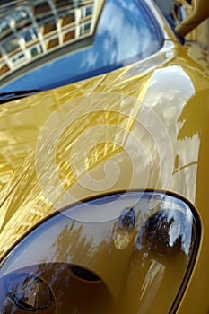 Vertical closeup shot of the headlights of a yellow sports car