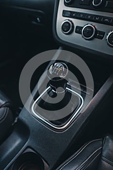 Vertical closeup shot of a manual transmission in black car interior